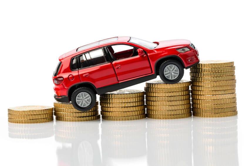 Red toy car sitting on top of a staircase of coins.