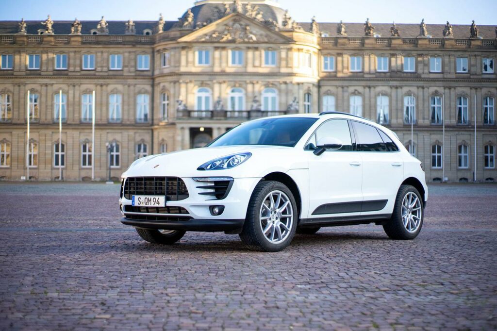 A Porsche Macan SUV on a brick road.