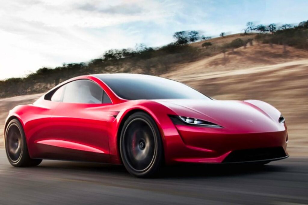 A red Tesla Roadster electric convertible car.