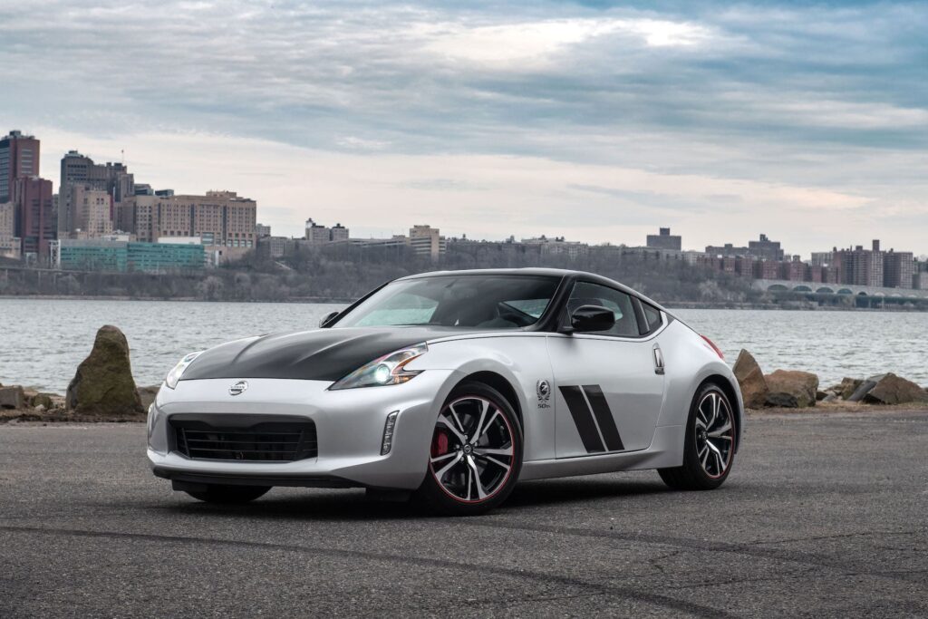 A Nissan 370Z parked on a road next to a river.