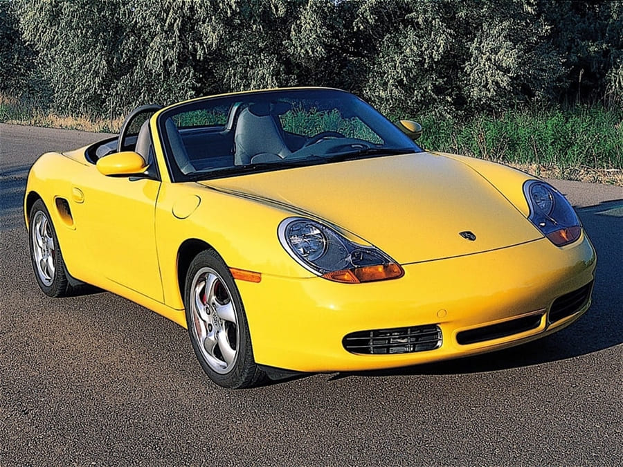 A parked yellow 1999 Porsche Boxster