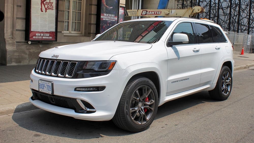 A parked white 2015 Jeep Grand Cherokee