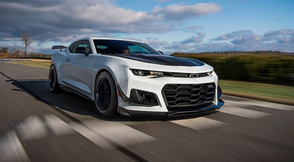 A white 2022 Chevrolet Camaro ZL1 speeding down a road