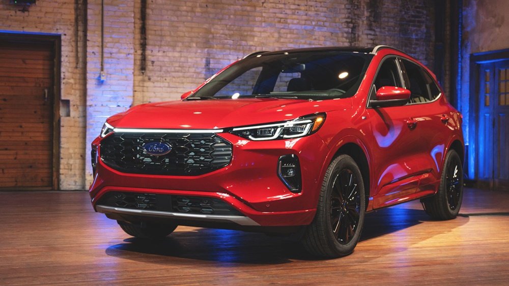 A red 2023 Ford Escape Hybrid in a showroom