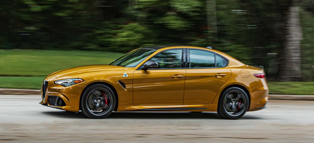 A golden 2023 Alfa Romeo Giulia Quadrifoglio on the road