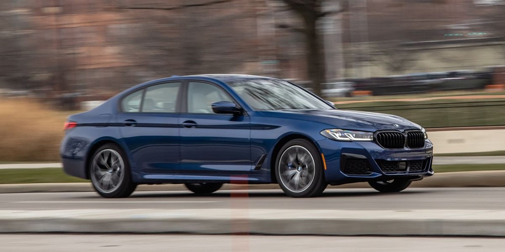 A dark blue 2022 BMW 5-series on the move