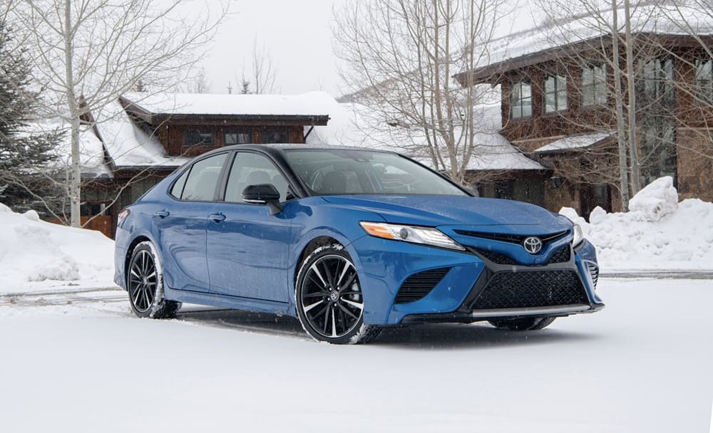 A blue 2020 Toyota Camry parked in snow