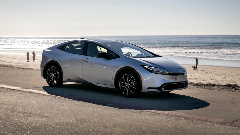 A parked white 2023 Toyota Prius by the beach