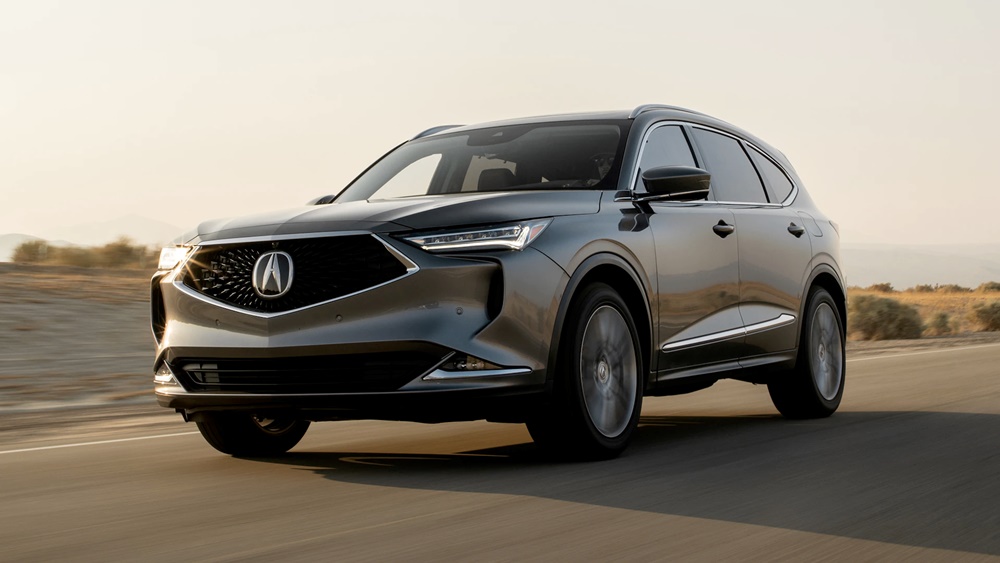 A sunlit silver 2023 Acura MDX on the move