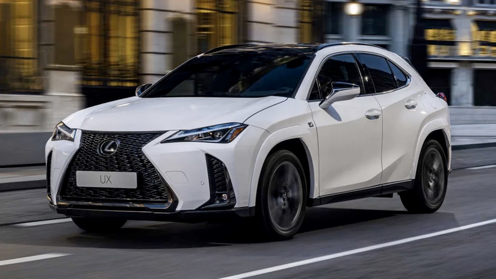 A white 2023 Lexus UX250h driving down the road