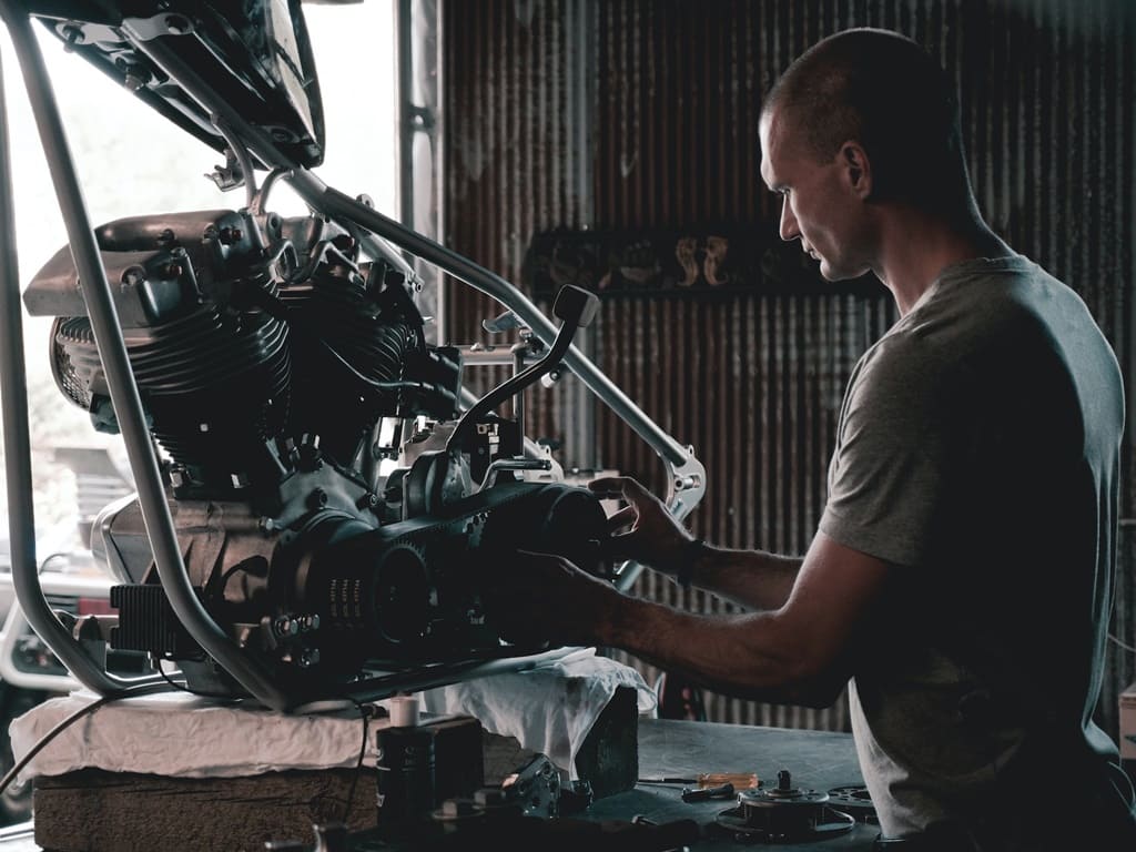A mechanic examines a car engine