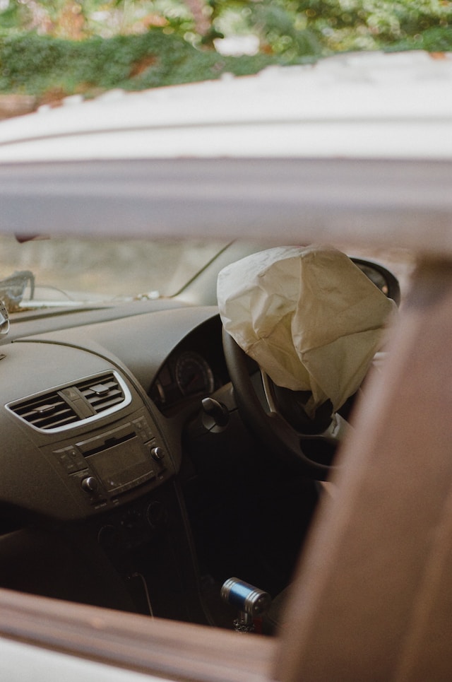 A deflated airbag jutting out from a car's steering wheel