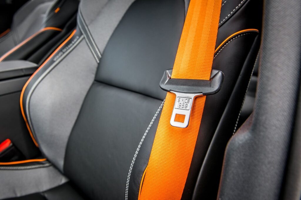 An orange seat belt in a sports car