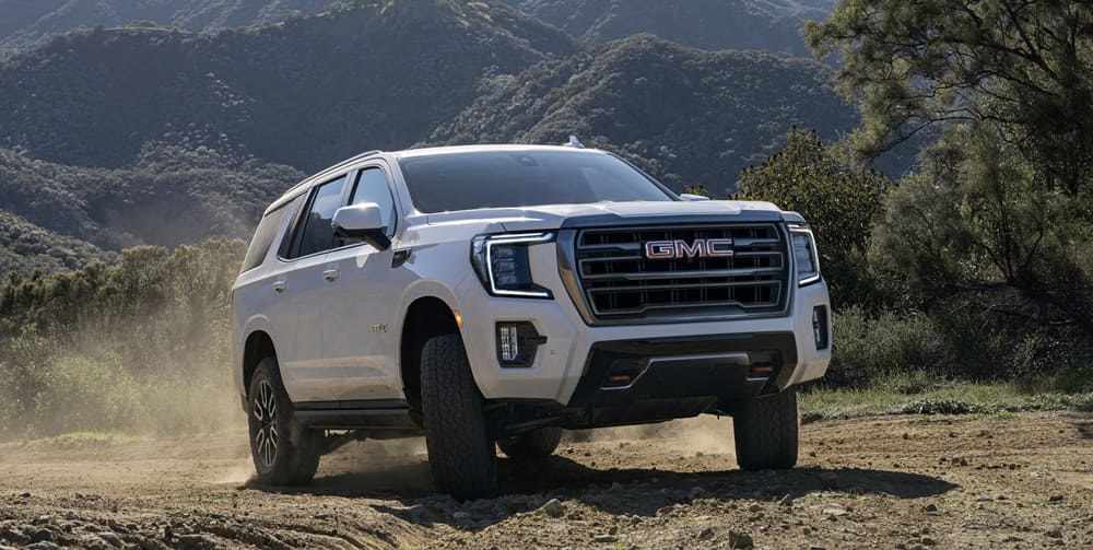 A white 2022 GMC Yukon SLT hitting the trail